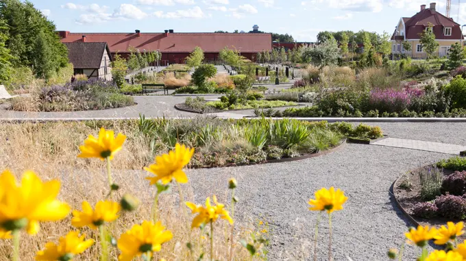 A park with flowerbeds, benches and walkways.