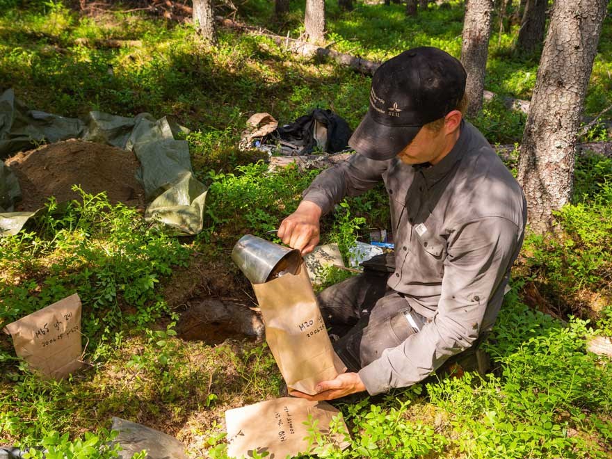 Person sorting soil samples at  sample site. Photo.