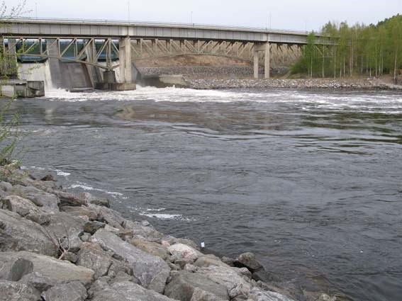 River with bridge and hydroelectric power plant dams in the background. Photo.