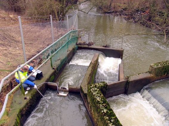 Man taking water samples in a fish ladder. Photo.
