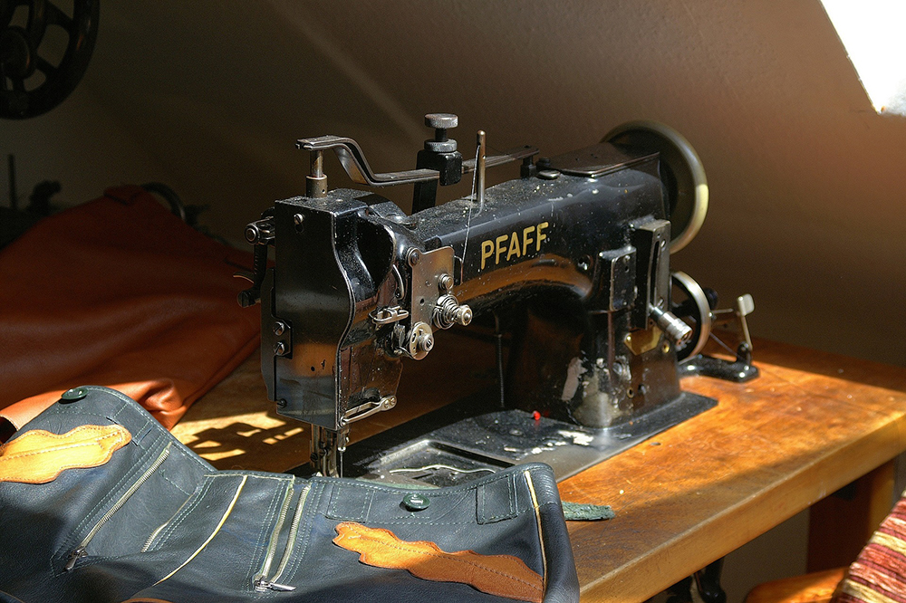 En gammeldags symasking som lagar klädesplagg.