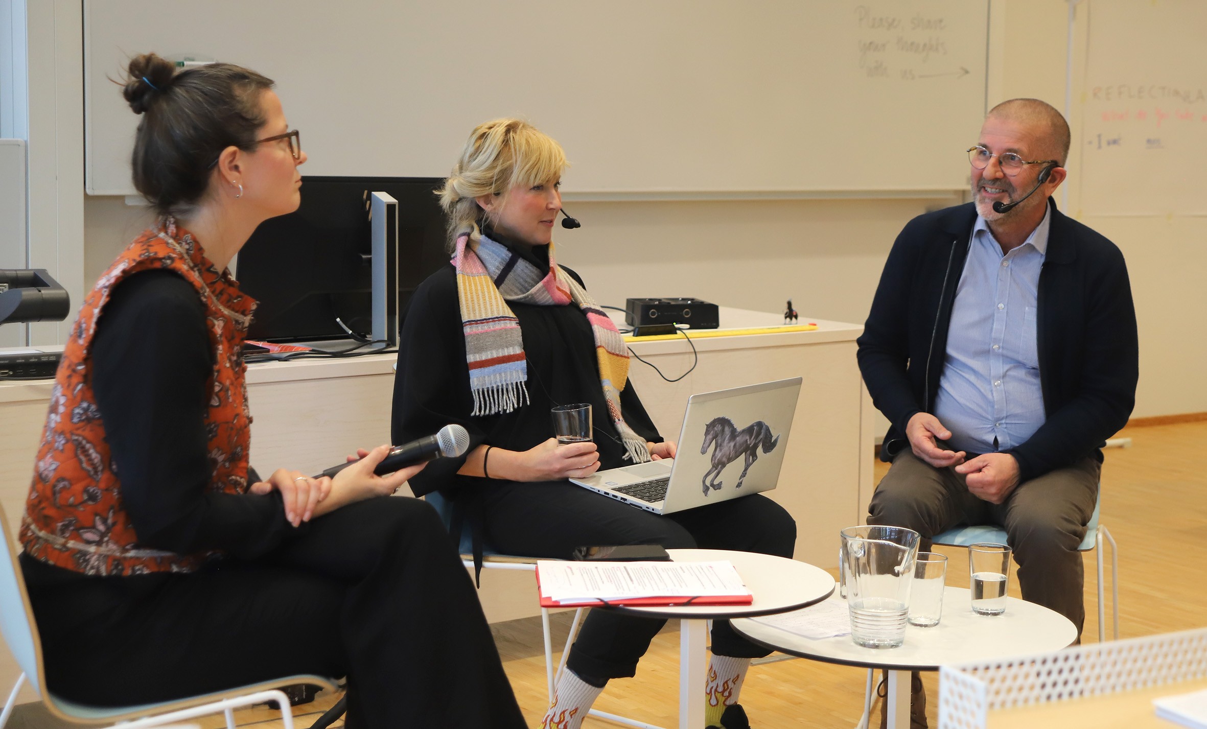 Picture of three participants in a panel debate. 