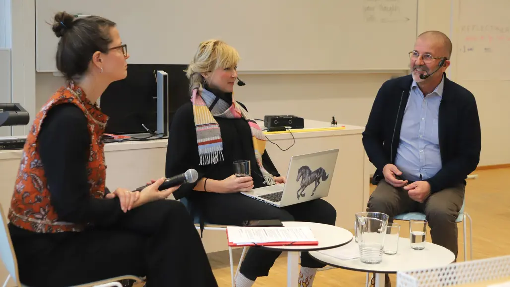 Picture of three participants in a panel debate.