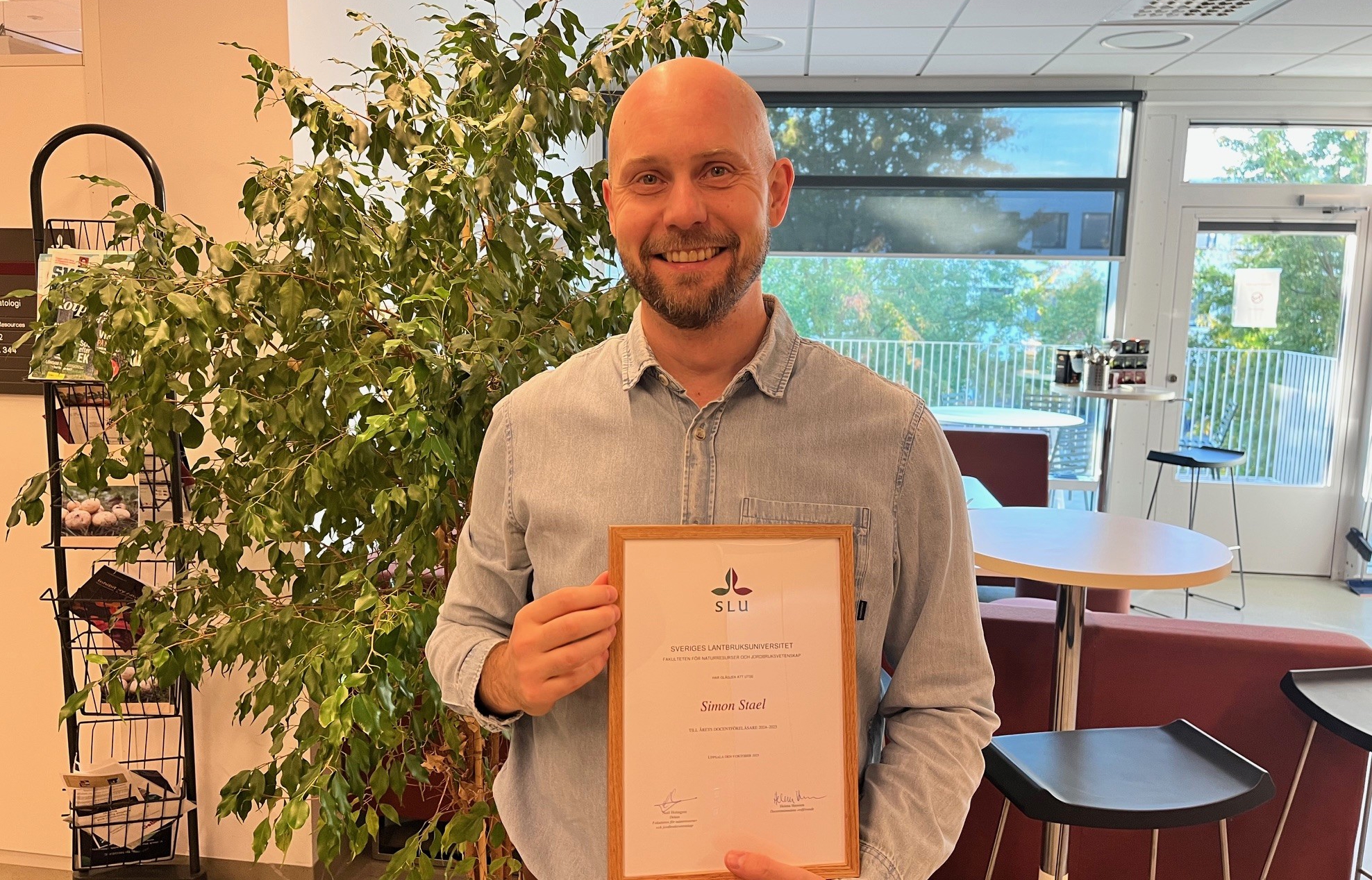 Dr. Simon Stael holding the best docent lecture certificate.