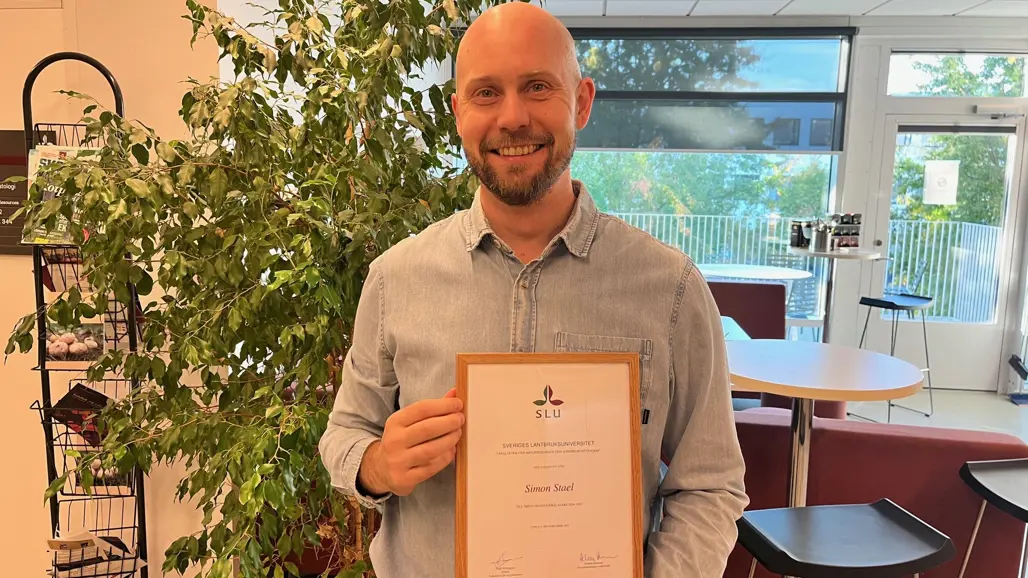 Dr. Simon Stael holding the best docent lecture certificate.