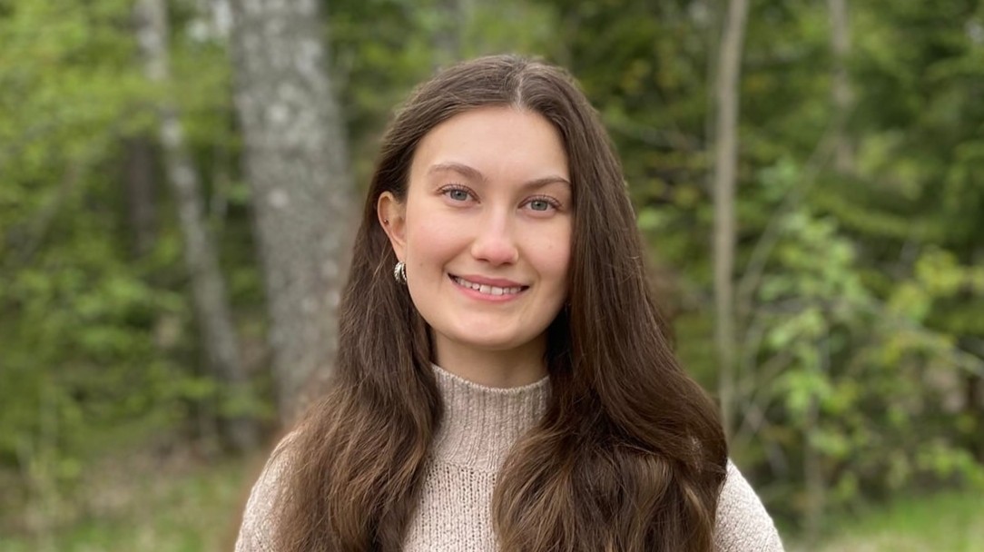A young woman, smiling at the camera