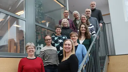 12 persons standing on staircase. Group photo.