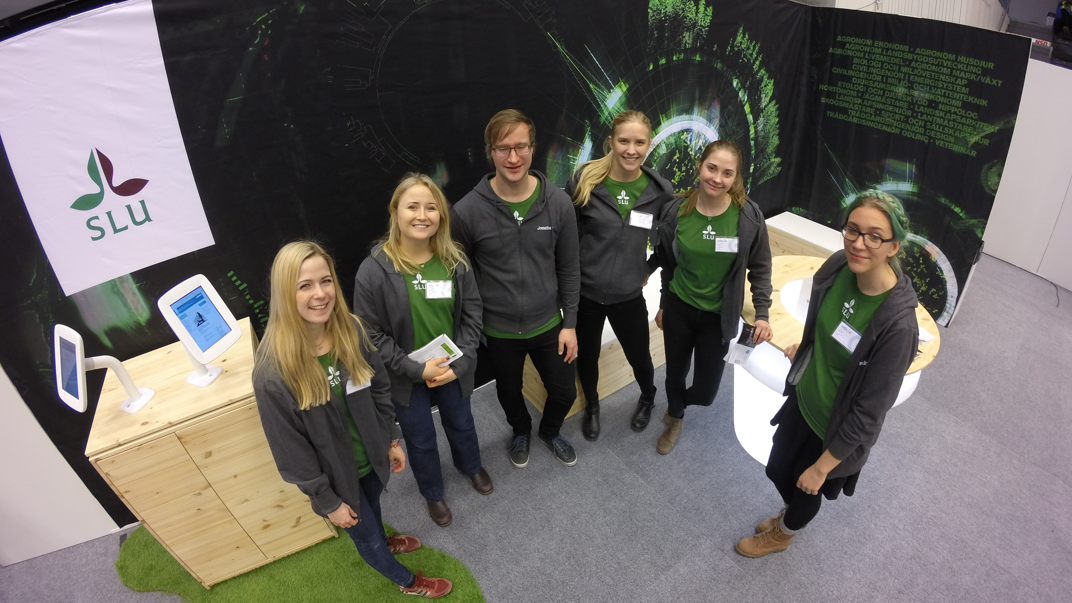 Student communicators look smilingly up from SLU's exhibition stand.