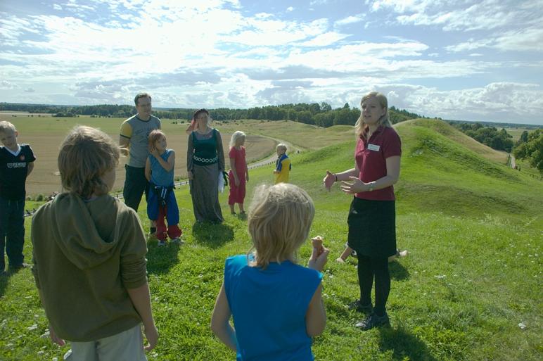 Personer ute vid gravhögar