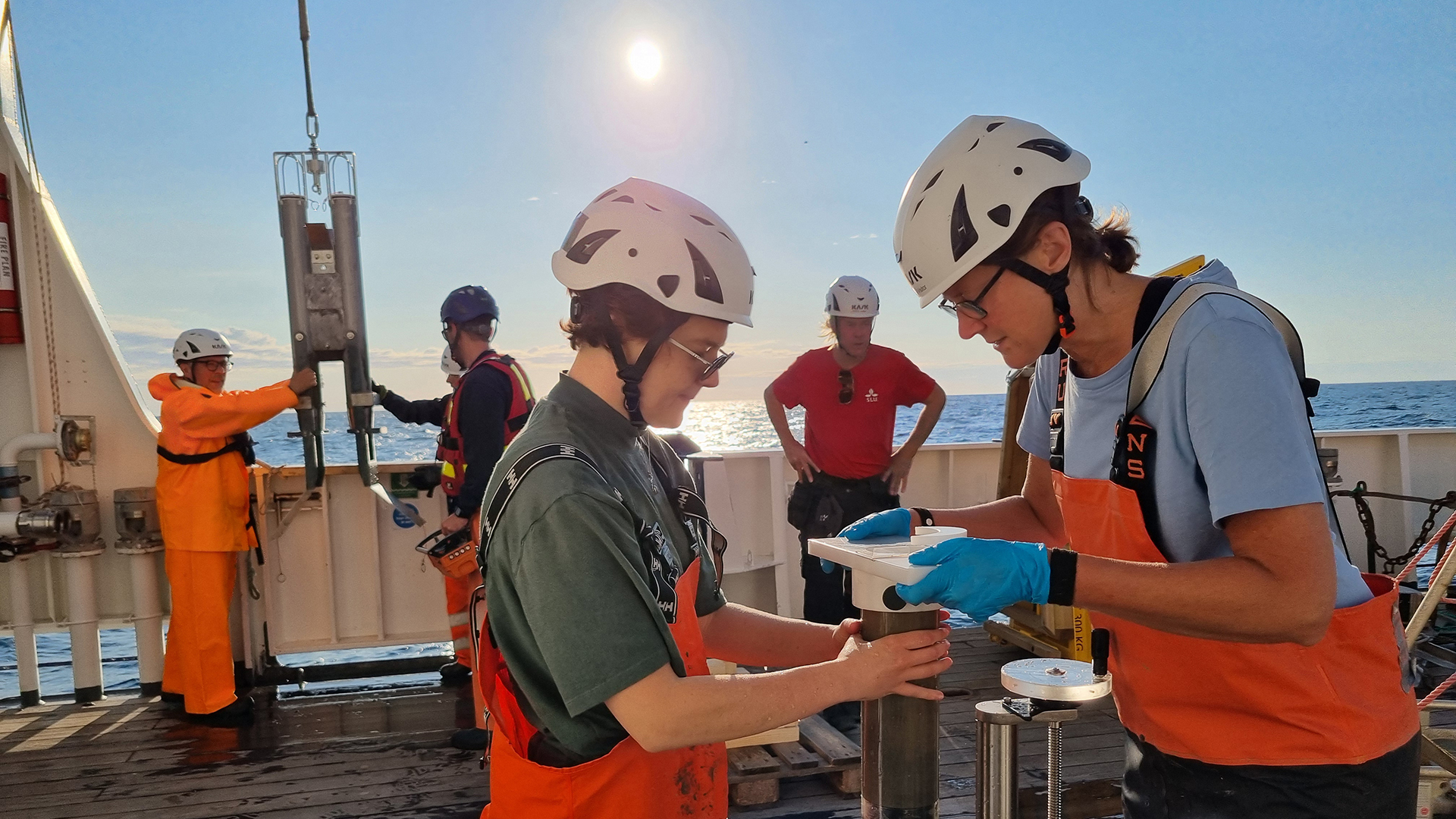 Researchers examine a seafloor sample on deck