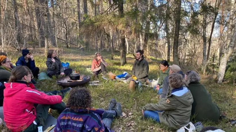 People sitting on the ground in a forest