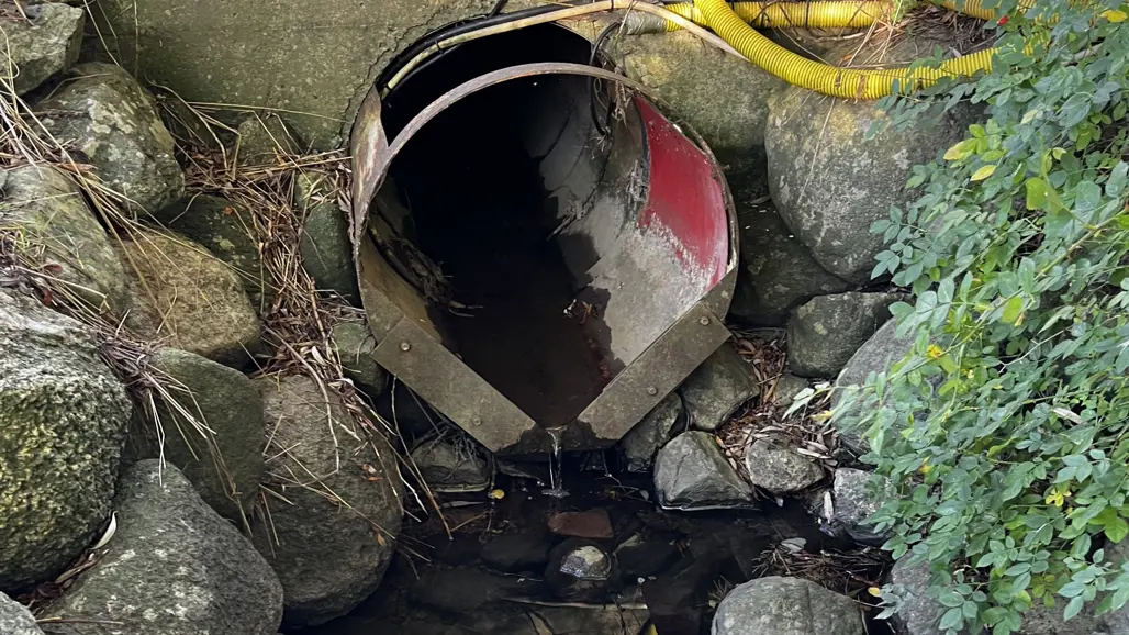 Mynningen av ett dräneringsrör i en liten bäck
