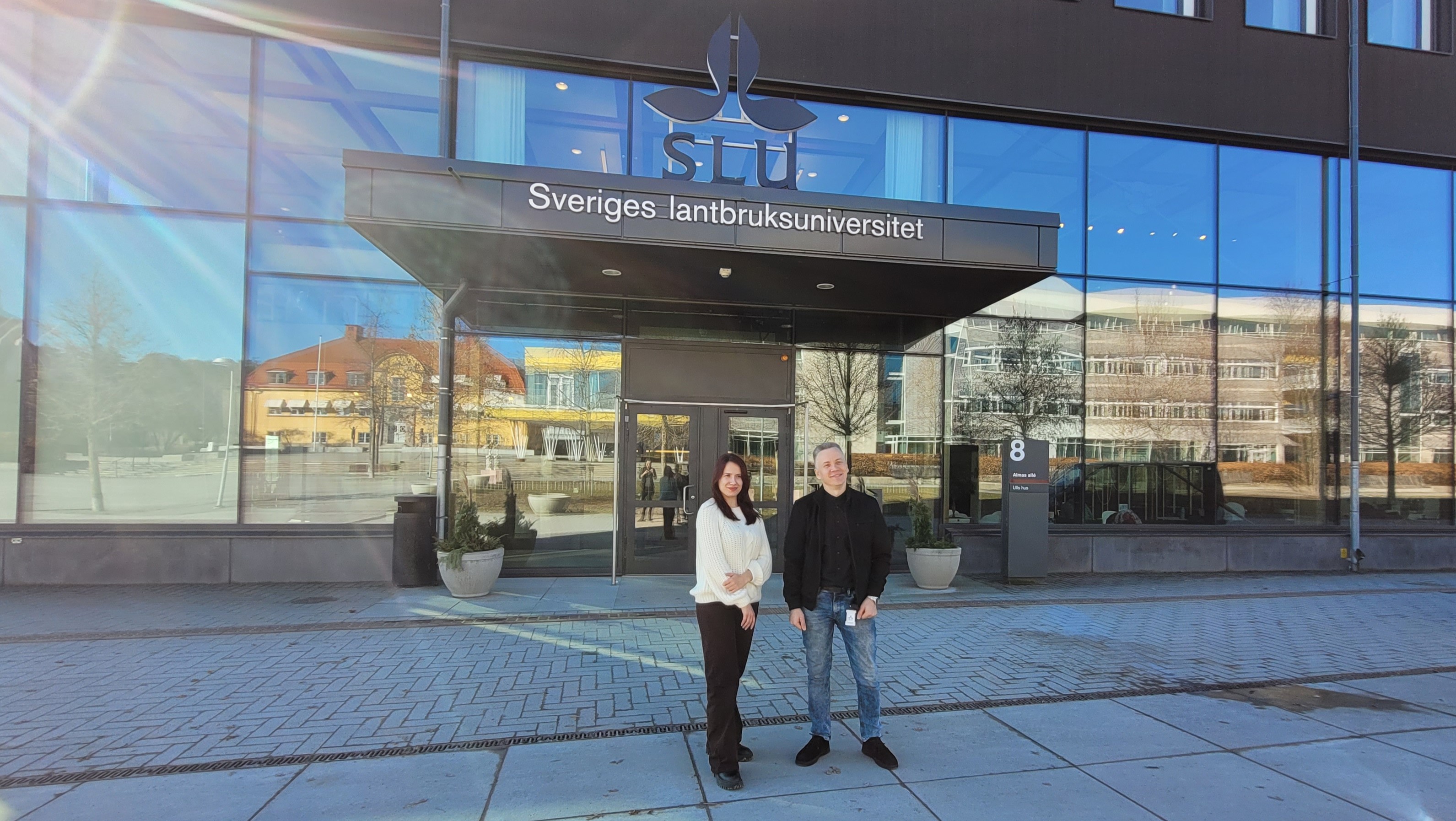 Two persons outside the entrance to SLU Uppsala
