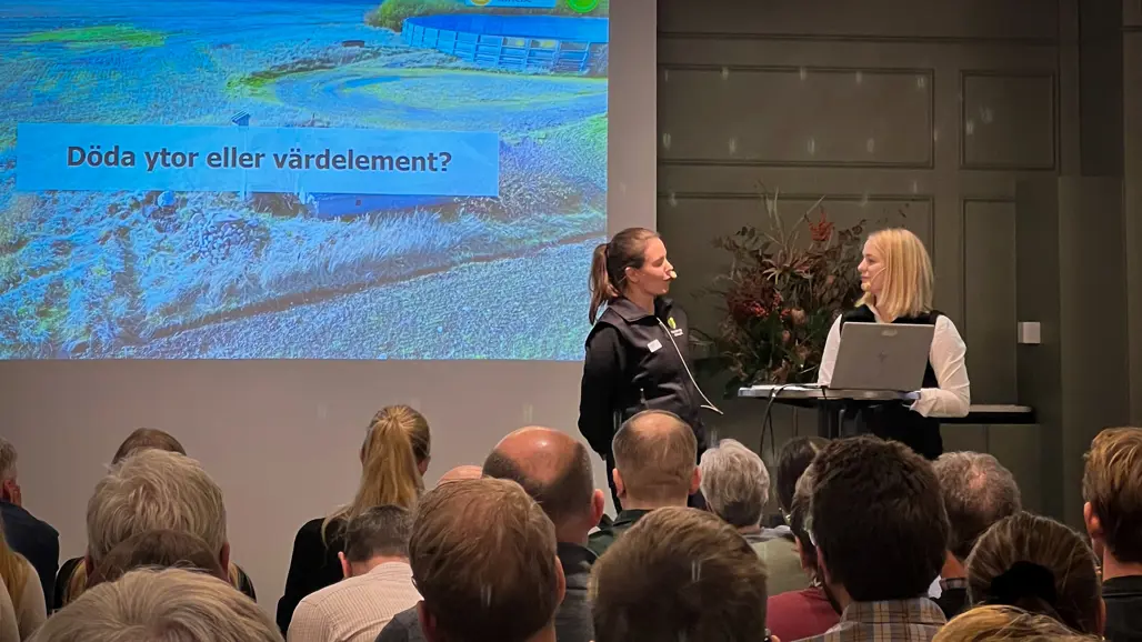 Två kvinnor framför en stor publik