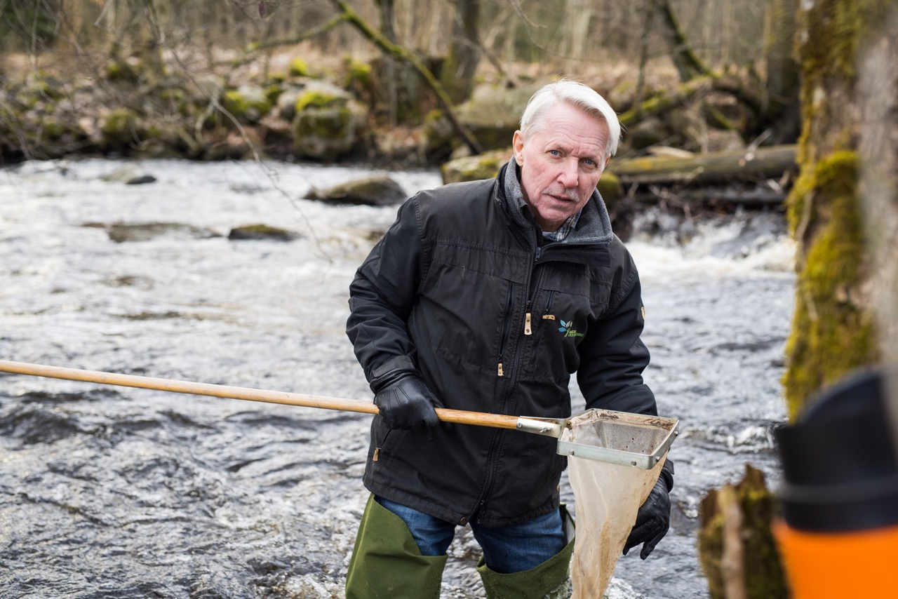 En man med håv i vatten