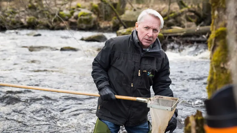 En man med håv i vatten