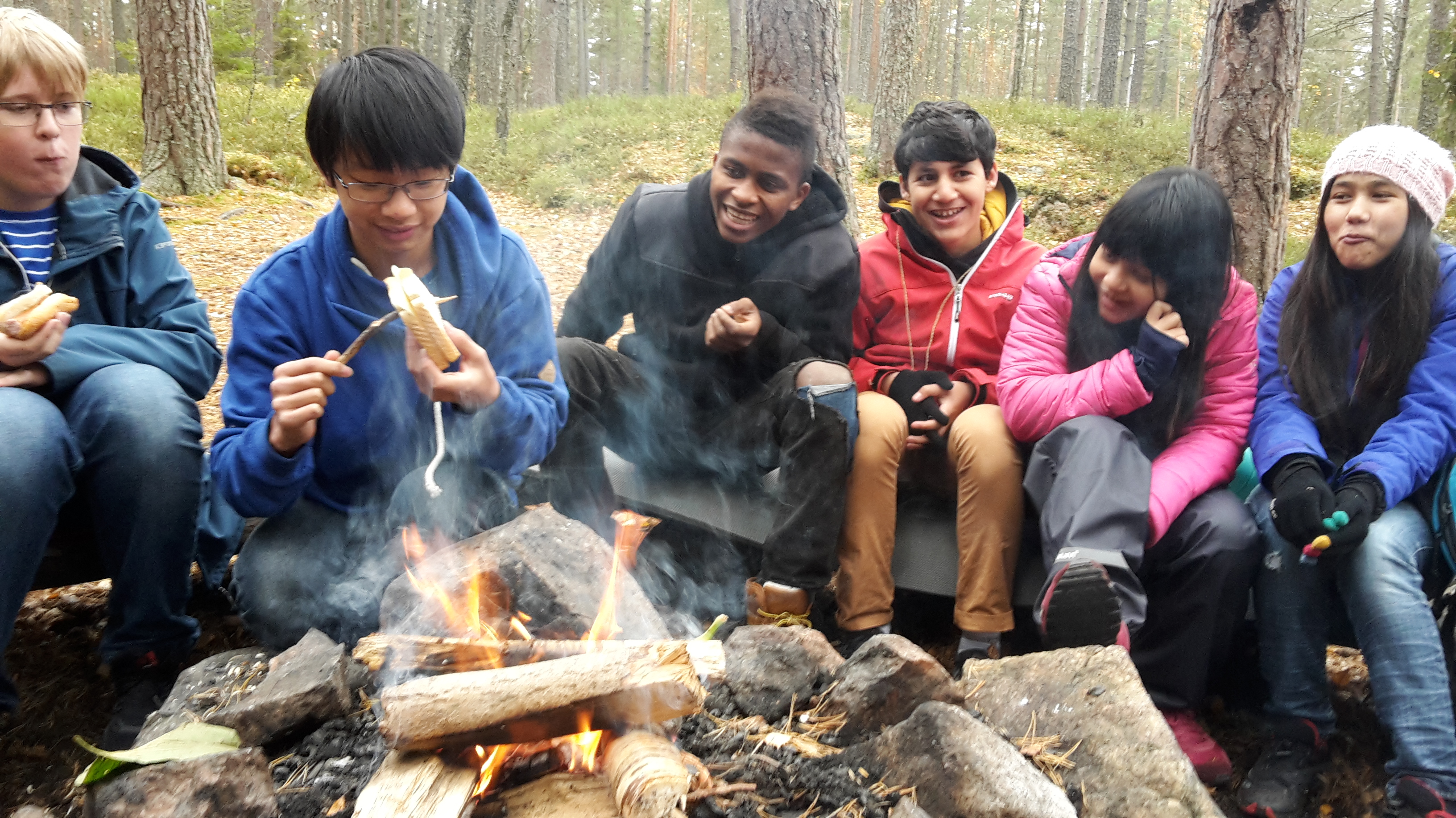 A group of people sitting around a fire. 