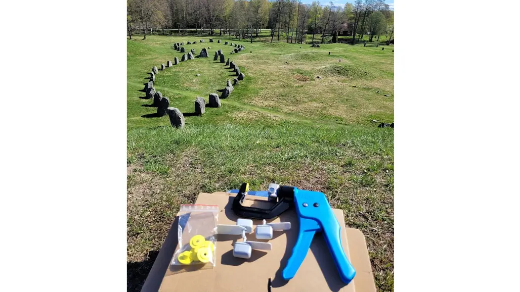 Ett blått aktivitetsmätarverktyg på ett bord, fornlämningar i bakgrunden. Foto.