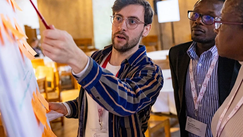 A man speaking with a pen in his hand. Photo.