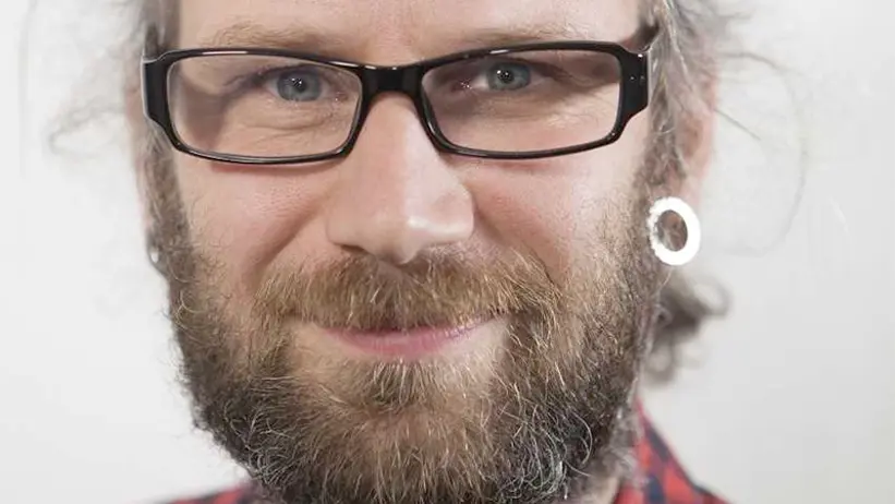 Portrait photo of a man with beard and glasses.