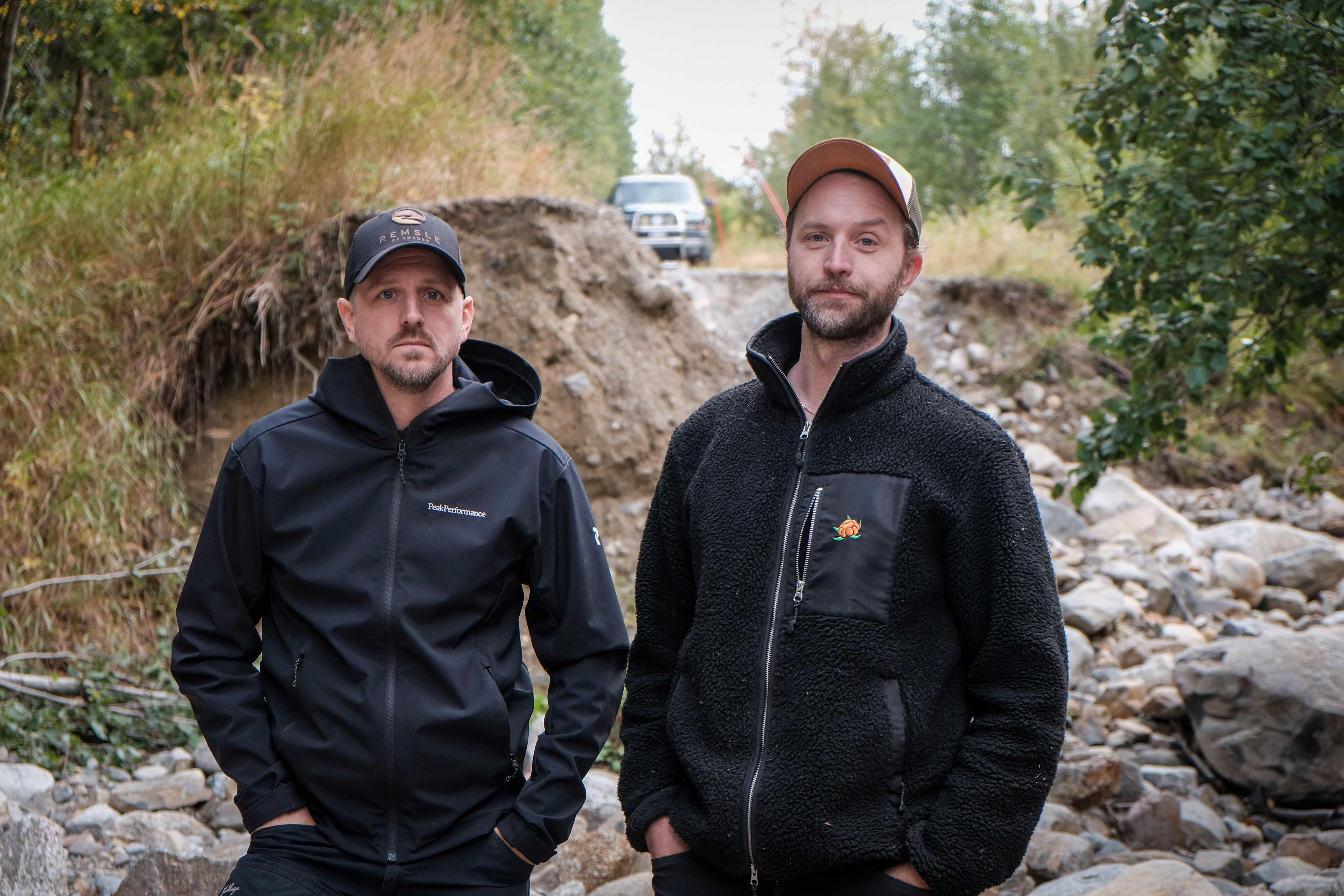 Per Åström och Erik Sundin står nere i hålet som blivit kvar efter att vägen spolats bort en bit utanför Skorped.