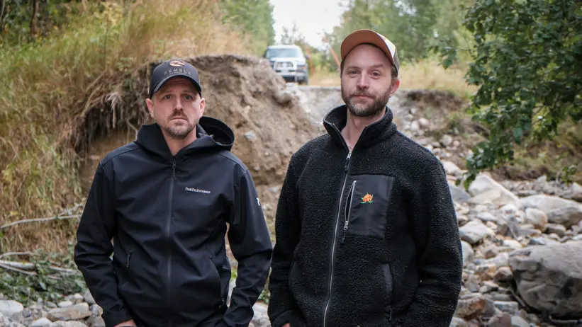 Per Åström och Erik Sundin står nere i hålet som blivit kvar efter att vägen spolats bort en bit utanför Skorped.