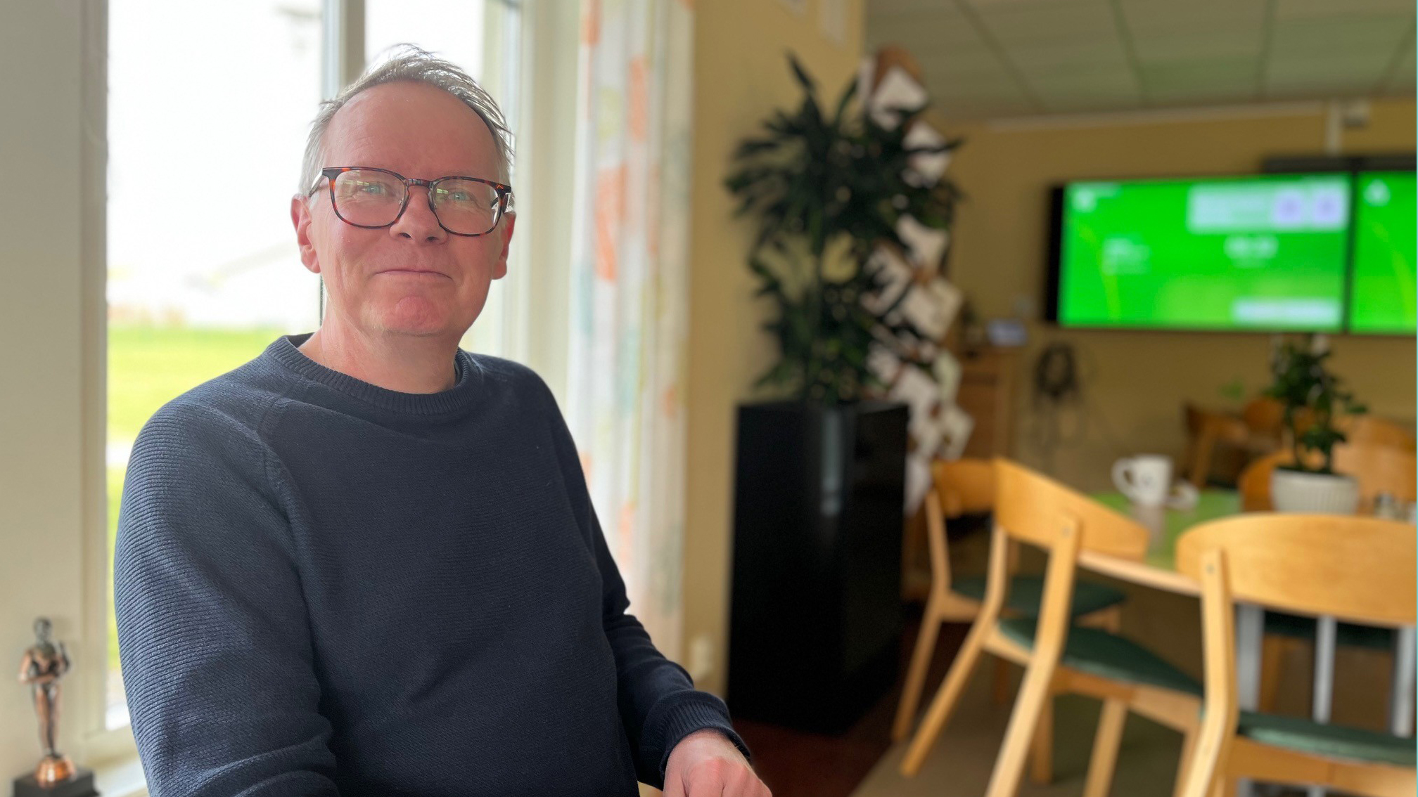 Man i glasögon ler in mot kameran