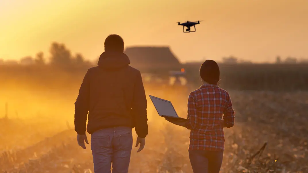 Two people on an agricultural field with a drone. Photo.