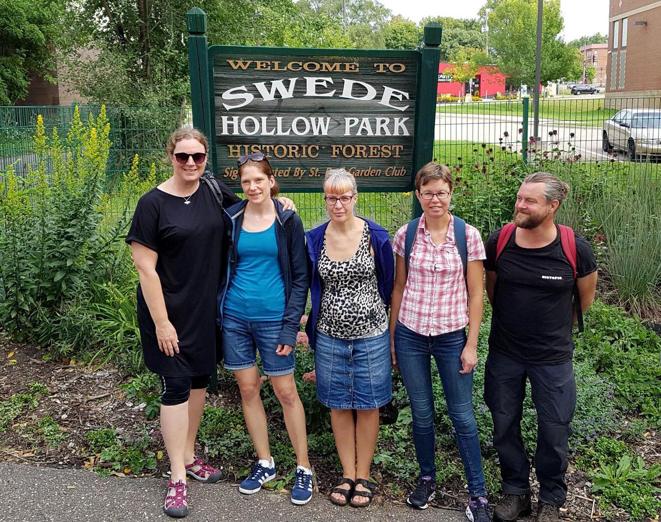 Fem personer vid en skylt