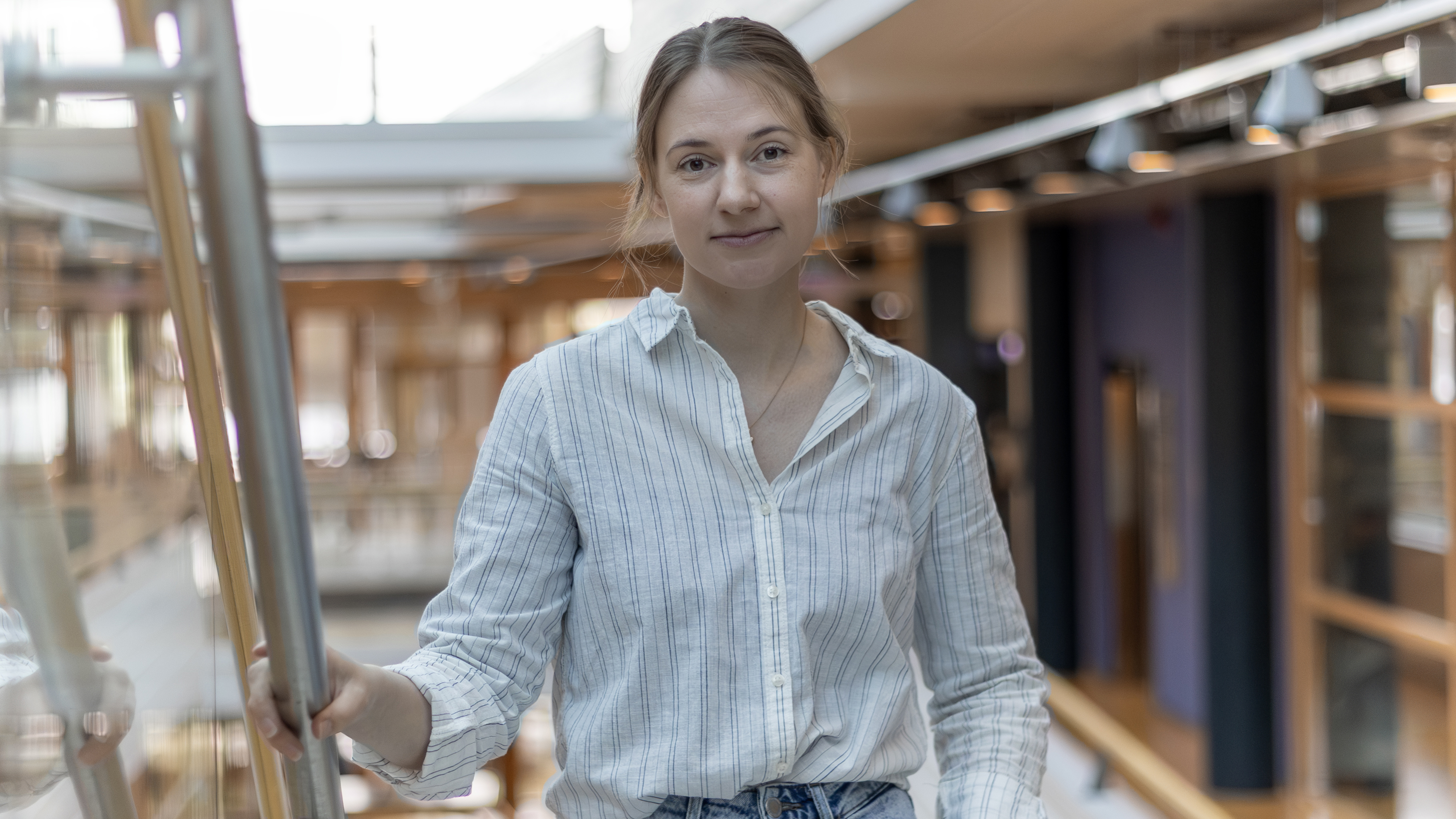 Porträttbild av en kvinna (Ebba Zetterberg, SLU) ståendes inomhus i trappa.