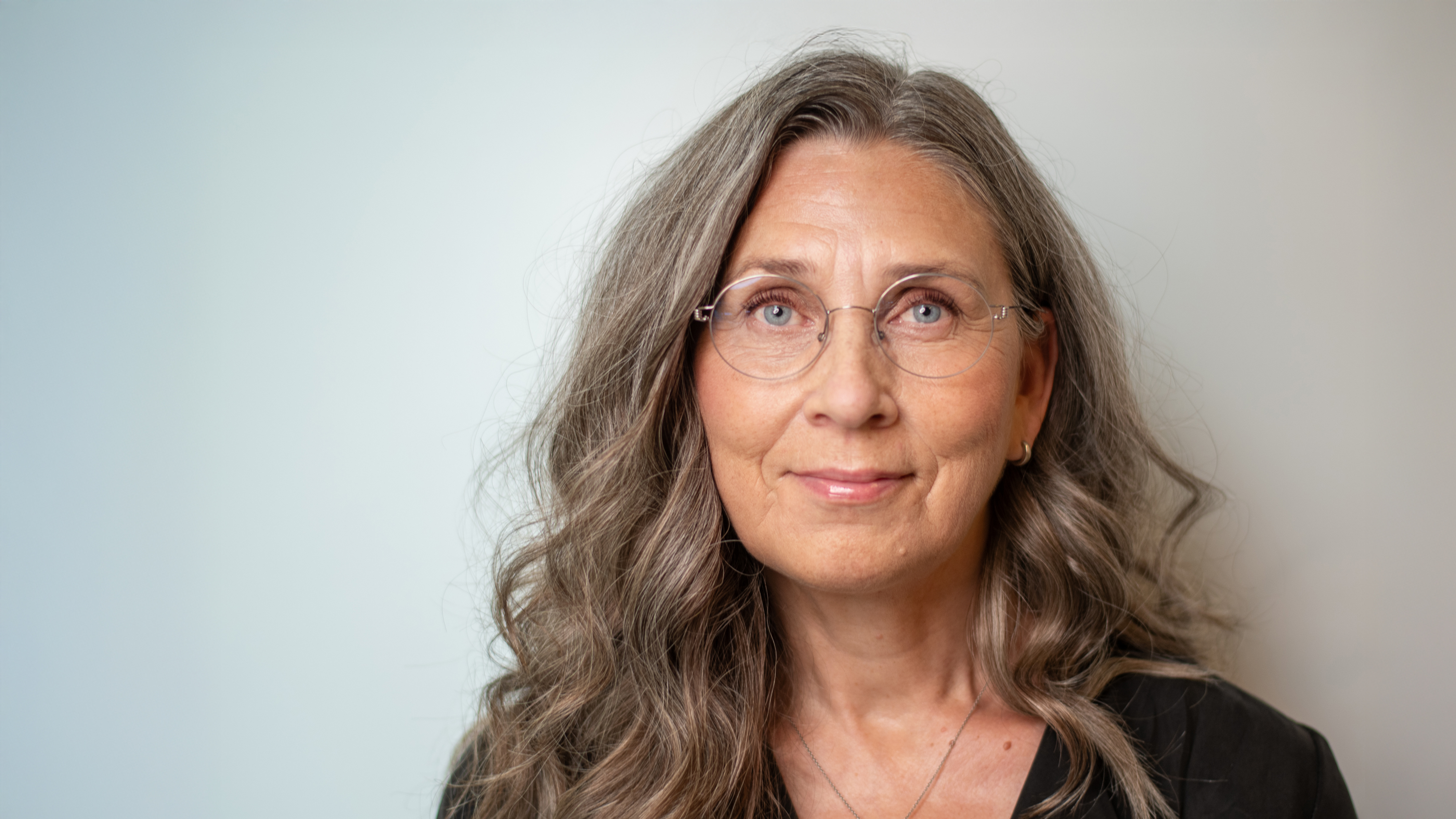 Porträttfoto på en kvinna mot vit bakgrund.