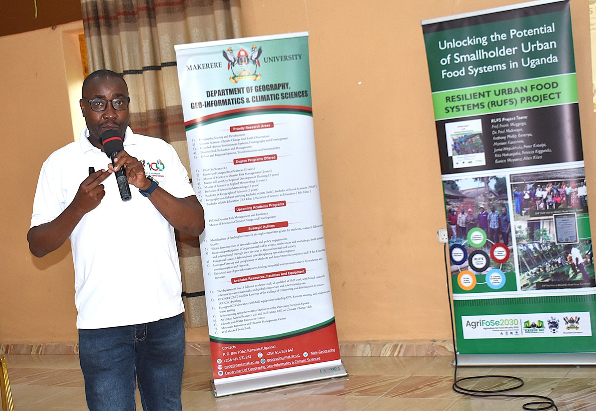 Man talking in mic with rollups behind