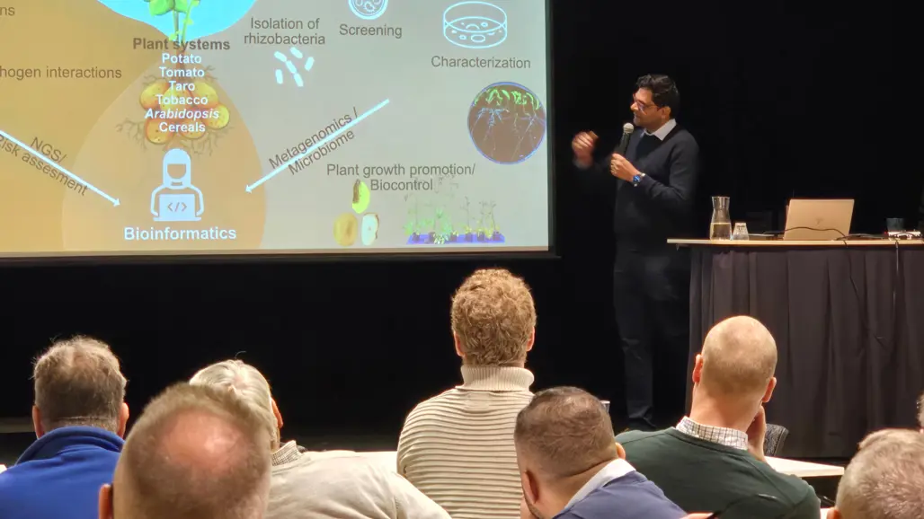 En man talar framför en publik. Foto.