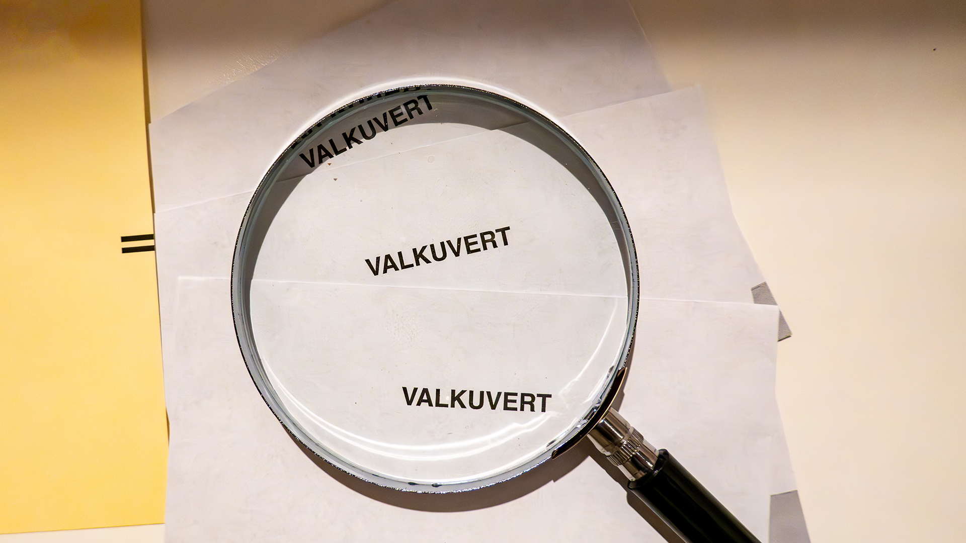 En hög med valkuvert med ett förstoringsglas liggandes ovanpå.