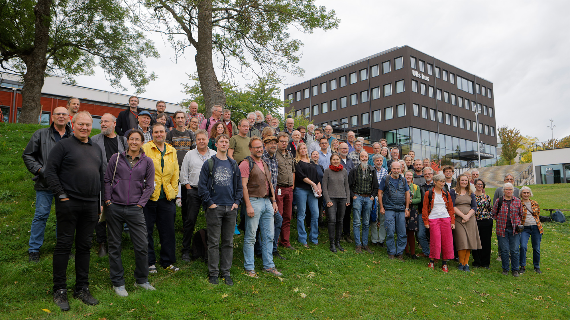 En stor grupp av människor står uppställda på gräsplätt. Foto