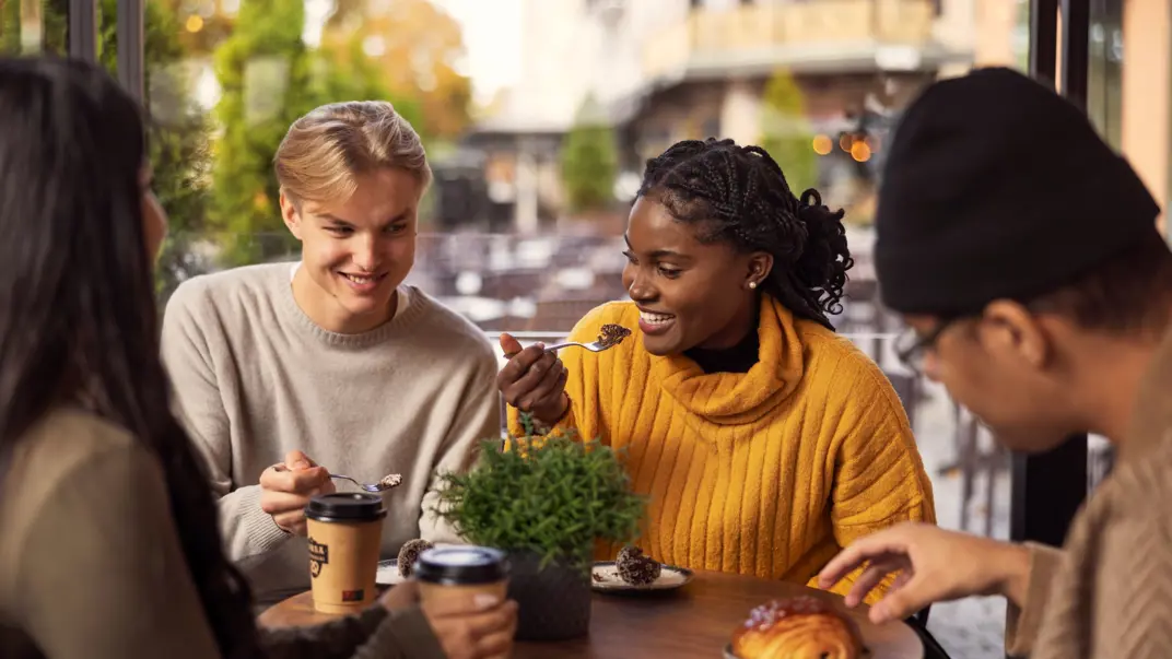 three young people are sitting in a café