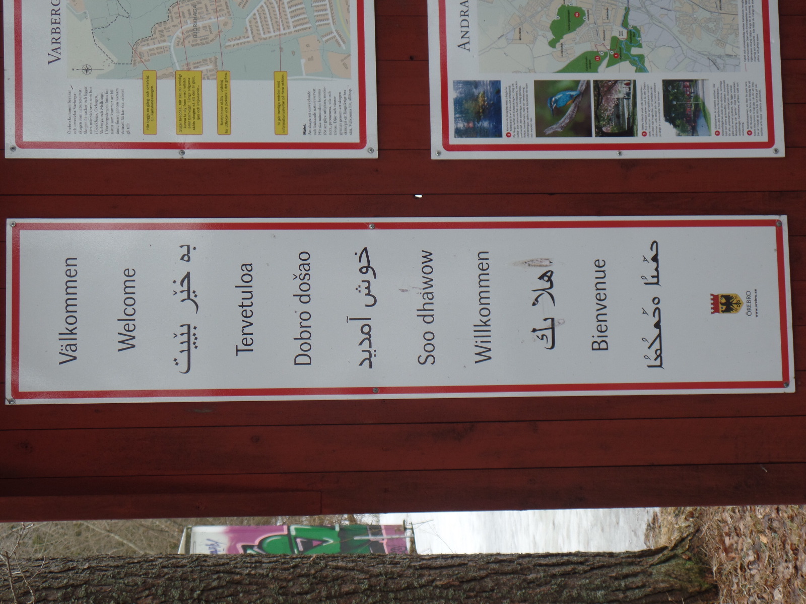 Foto: En flerspråkig välkomstskylt. Benedict Singleton, 2018.