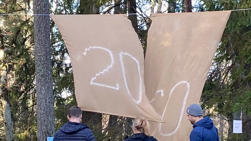 En stort draperi som hänger i träden med texten 2050