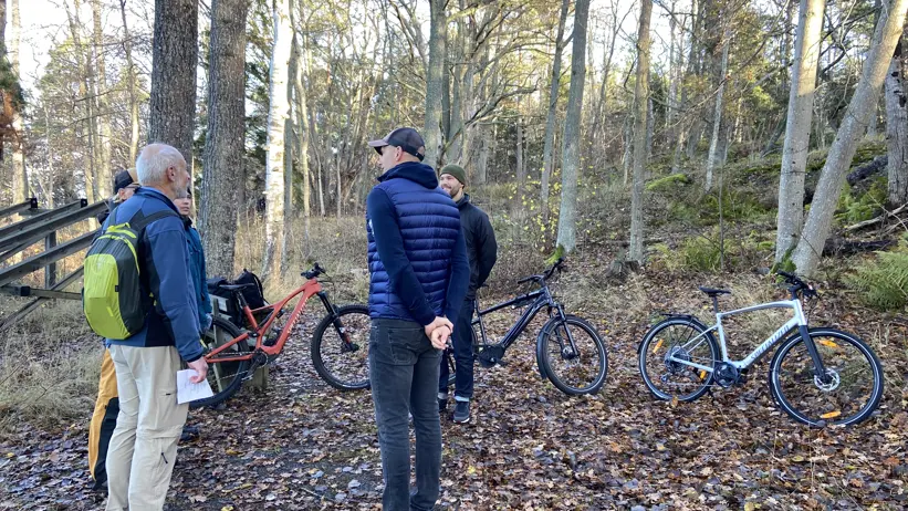 Personer står och pratar vid några cyklar