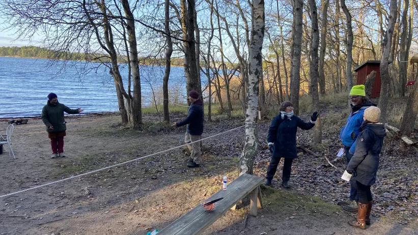 Personer vid en strand med en avgränsande snöre.