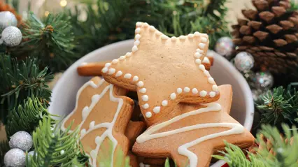 Pepparkakor i en skål med granris i bakgrunden. Foto.
