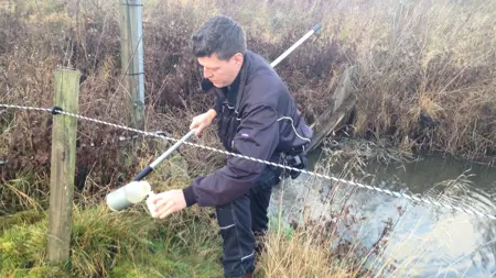 Mattias Gustafsson tar vattenprov. Foto: Sofia Delin.