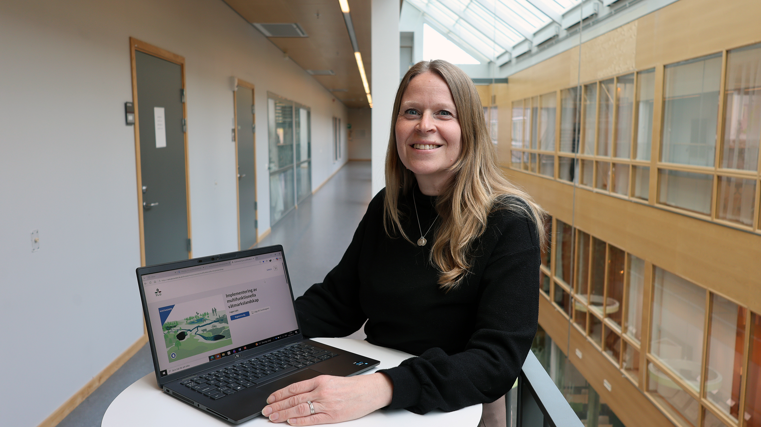 Kvinna visar kurssida på laptop.