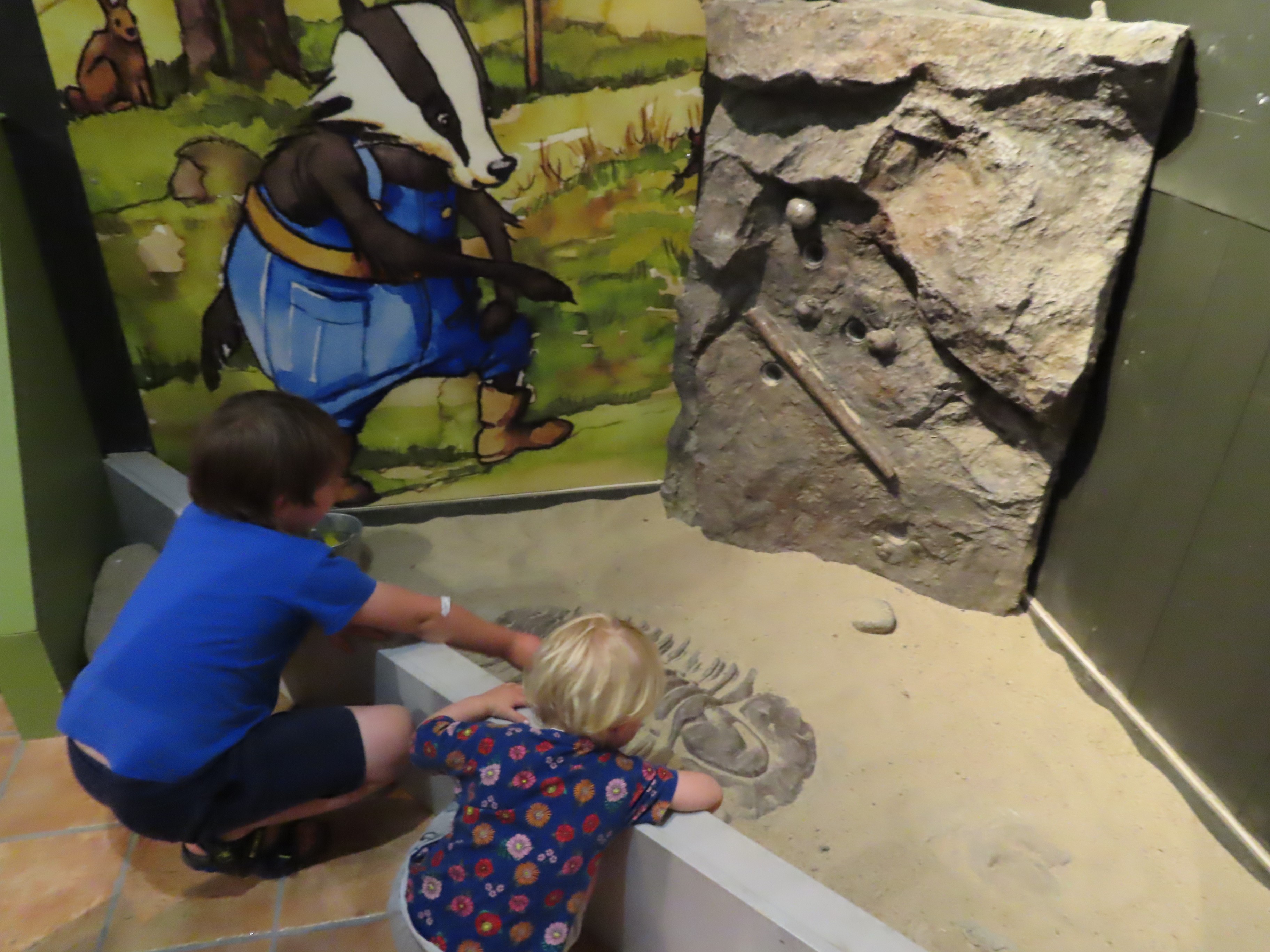 Barn leker med stenar i en utställning