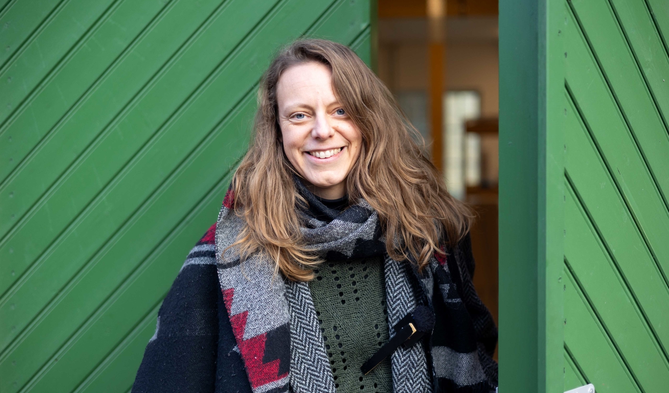 kvinna öppnar en grön dörr