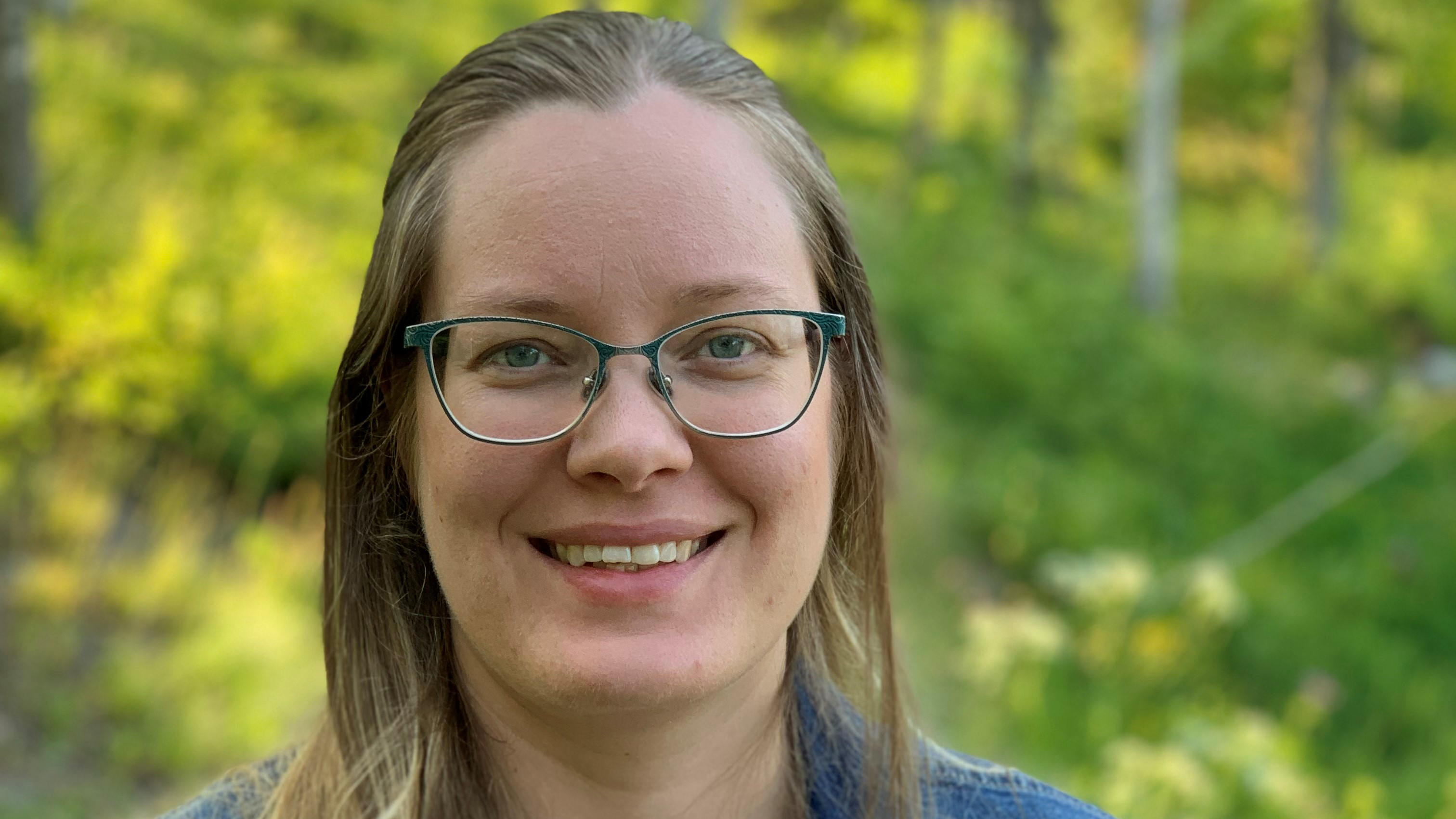 Person utomhus i grönskande miljö.