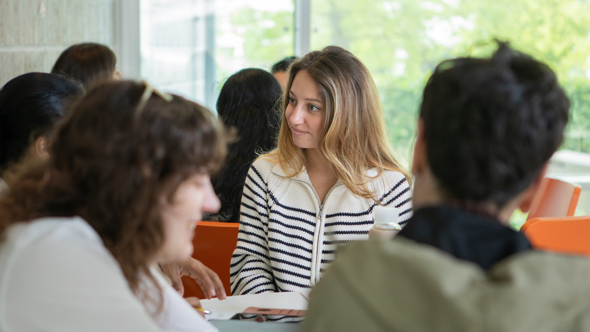 Students talking round a table.