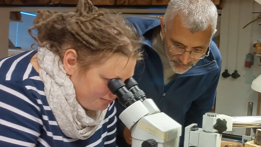 two persons and a microscope