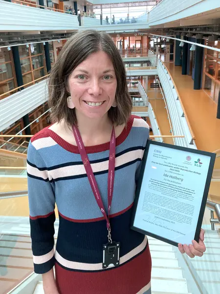 Researcher holding a diploma. Photo.