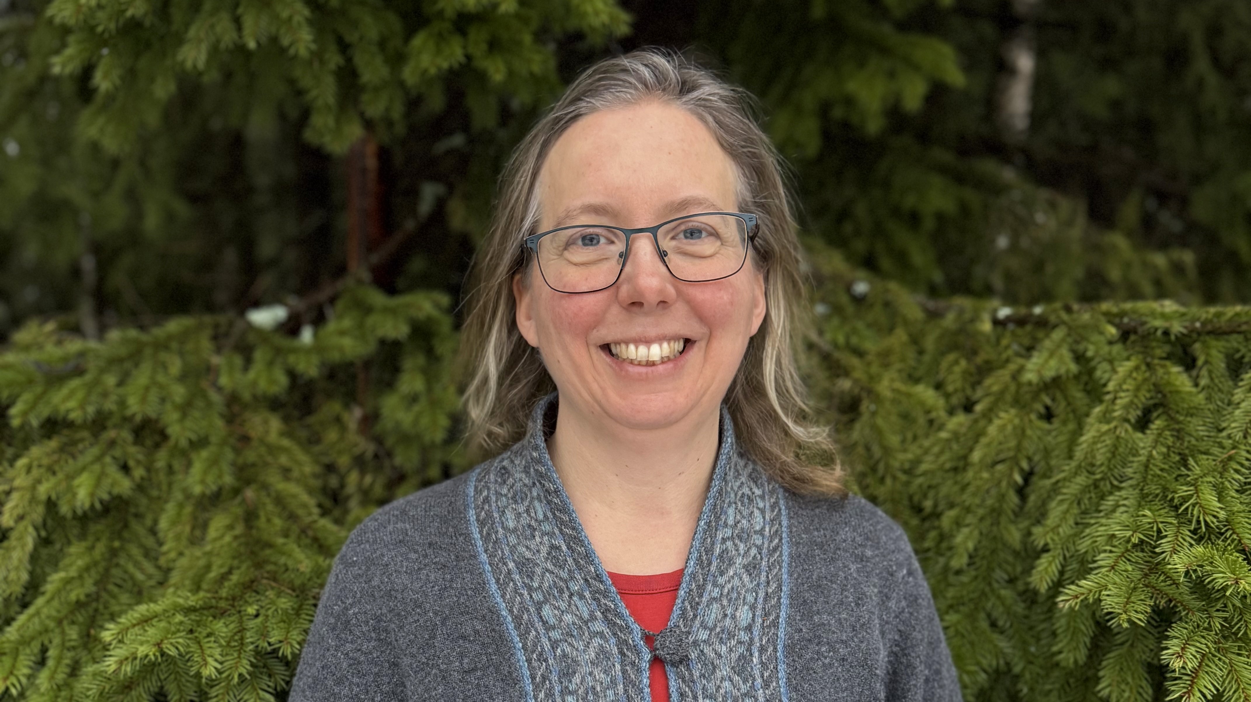 Kvinna framför en gran.